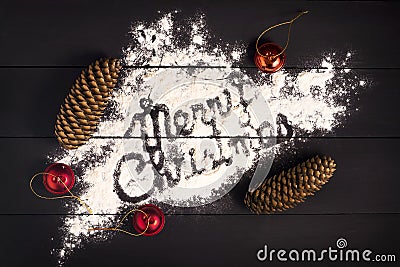 The inscription Merry Christmas , written with flour on a dark wooden background. Christmas greeting card. Stock Photo