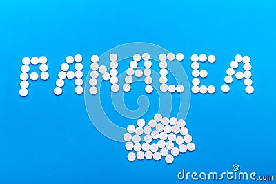 The inscription "Panacea" made of pills on a blue background Stock Photo