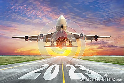 Inscription on the runway 2023 surface of the airport road with take off big airplane. Concept of travel in the new year, holidays Stock Photo