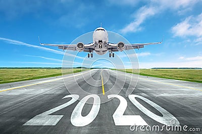 The inscription on the runway 2020 surface of the airport runway with take off aircraft. Concept of travel in the new year, Stock Photo