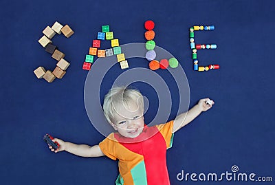 Inscription SALE made from different toys and cute smiling blond Stock Photo