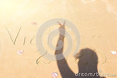 inscription on the sea coast of Vietnam 2020. silhouette of a girl on the sand Stock Photo