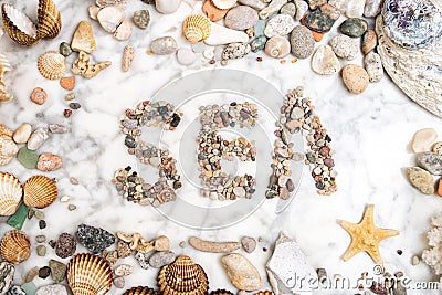 Inscription sea with pebbles, star, stones and shells lying on a marble background, composition of sea stones and seashells, word Stock Photo