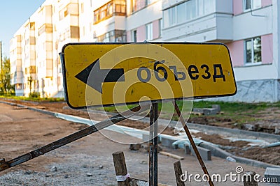 The inscription on the sign `Detour` in Russian. Road works in a residential area Stock Photo