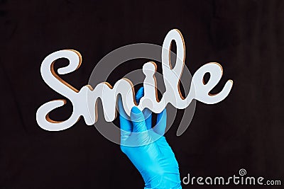 The inscription Smile in the hands of a doctor surgeon dentist. Stock Photo