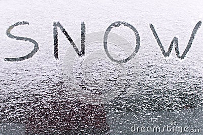 The inscription SNOW on the glass of the frozen car . Snowfall Stock Photo