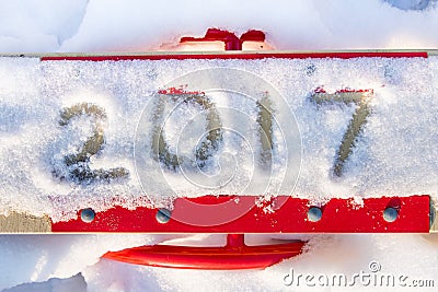 Inscription 2017 by snow on the red children's swing Stock Photo