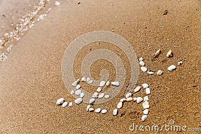 The inscription with stones in the sand the word Stock Photo