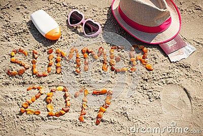 Inscription summer 2017, accessories for sunbathing and passport with currencies euro on sand at beach, summer time Stock Photo