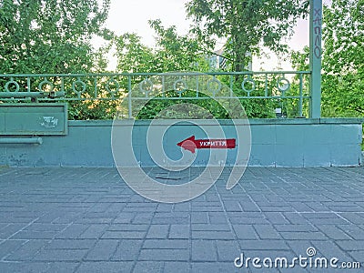 The inscription in Ukrainian SHELTER on the wall. Signpost direction to the bomb shelter in Ukrainian. Bomb shelter sign on the Stock Photo