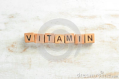 The inscription`VITAMIN` is laid out of wooden cubes. Stock Photo