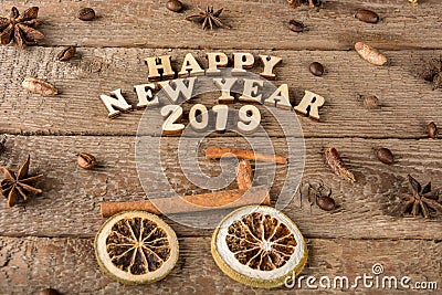 The inscription from wooden letters and numbers `Happy New Year`, a bicycle and a tree from spices on the background of rough wood Stock Photo