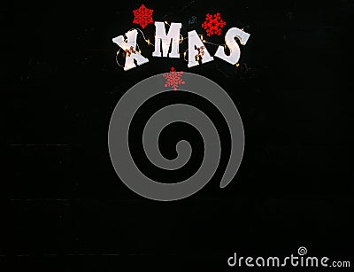 Inscription Xmas on black wooden background. Stock Photo