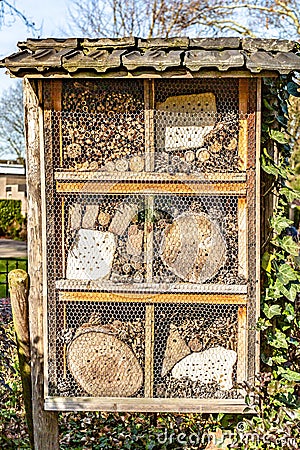 Insect hotel with small pieces of wood and wire mesh Stock Photo