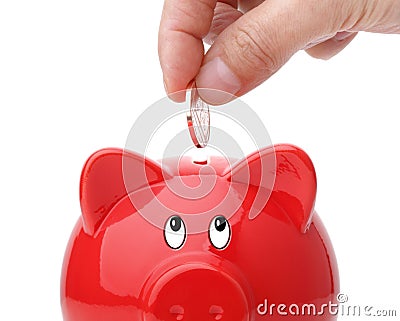 Inserting coin into a piggy bank Stock Photo