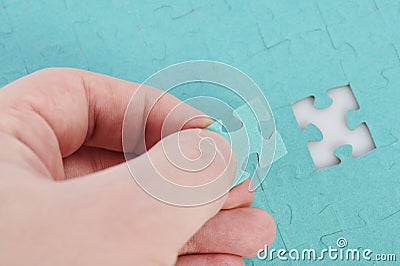 Inserting last piece to puzzle Stock Photo