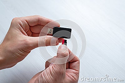 Inserting mini SD memory card in card reader concept. Hand holding memory card and inserts it into the usb reader Stock Photo