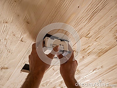 Insertion of square lamp on wooden ceiling Stock Photo