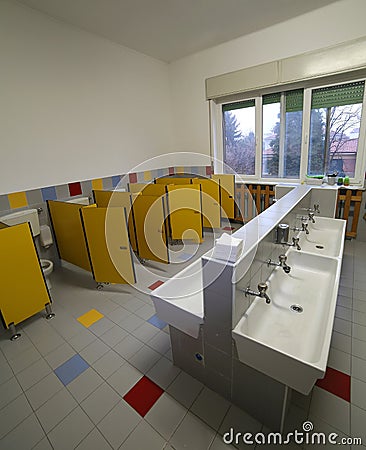 Inside a bathroom of a nursery school with small toilets and sin Stock Photo