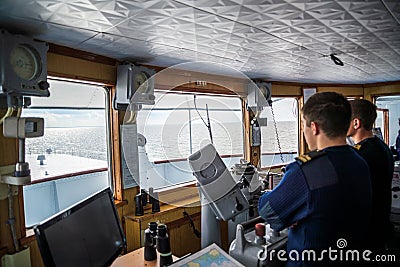 Inside the Captain`s bridge of passengers ship with blurred figures of staff one early autumn Editorial Stock Photo