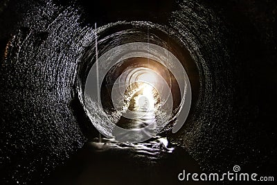 Inside dark round underground sewer tunnel Stock Photo