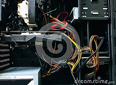 Inside details of the personal computer. Wires. Motherboard and video card in the dust. Broken PC Stock Photo