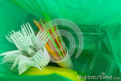 Inside of green plastic bag with single use cutlery and packages Stock Photo