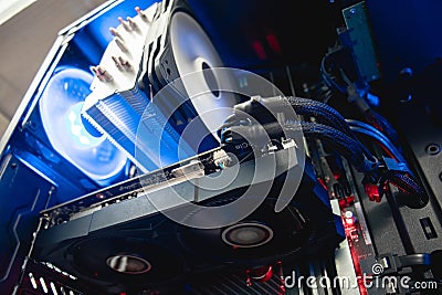 Inside of a professional gaming computer, video graphics card mounted on a motherboard/mainboard, blue shining fan - Bilder Stock Photo
