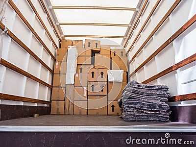 Inside of a removal van, packing boxes and blankets. Stock Photo