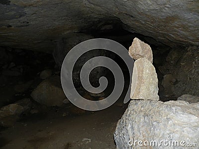 Inside a small cave with a balanced stone tower Stock Photo