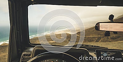 Inside view of car with mobile modern phone gps system to find the road and use maps in off road scenic place with beach and Stock Photo