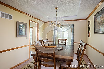 Inside view of a cozy dining room with a wooden table, chairs, and a chandelier Editorial Stock Photo