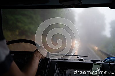 Inside view of human driving car during fog Stock Photo