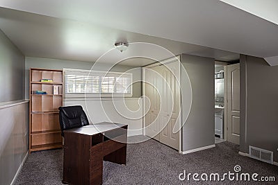 Inside view of a room with a working desk, wooden cabinet, and windows Editorial Stock Photo