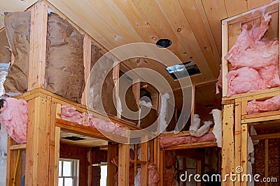 Inside wall heat isolation with mineral wool in wooden house, building under construction Stock Photo
