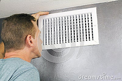 Inspecting a Home Air Vent for Maintenance Stock Photo