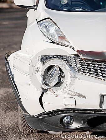 Inspection of the car after an accident on the road. The front fender and left headlight are broken, damaged and scratched on the Stock Photo