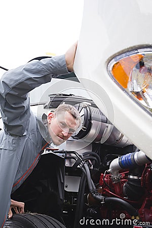 Inspector checking working engine on white big rig semi truck Stock Photo