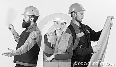 Inspector disappointed about employee, builder. Men and woman in helmets carefree with hammer and project Stock Photo