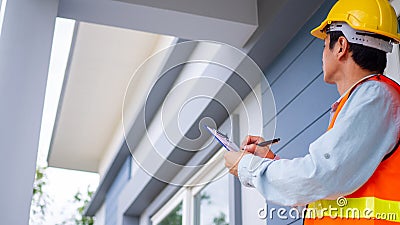 The inspector or engineer is checking the building structure and house roof specifications. After the renovate is complete Stock Photo