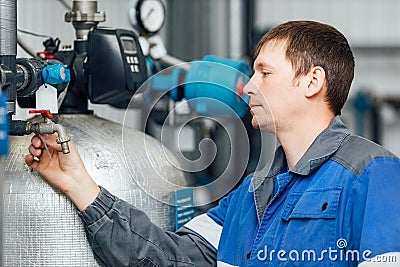 An inspector in overalls checks the condition of the water purification equipment. Stock Photo