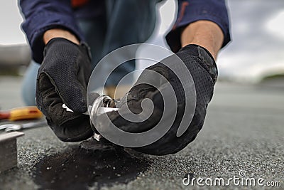 Inspector placing white yearly safety tag on to fall arrest fall restraint roof anchor point Stock Photo