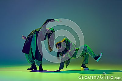 Inspiration. Young stylish flexible girls in modern attires dancing contemp style dance isolated over gradient blue Stock Photo