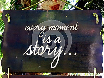 Inspirational motivation quote Every moment is a story on a sigh hanging in tree Stock Photo