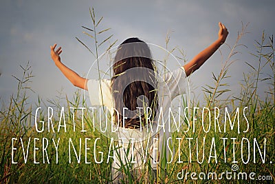 Inspirational motivational quote - Gratitude transforms every negative situation. With young woman in the field, standing alone Stock Photo