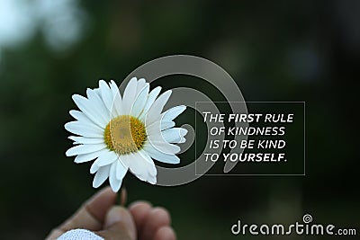 Inspirational quote - The first rule of kindness is to be kind to yourself. Self love care, healing concept with flower in hand. Stock Photo