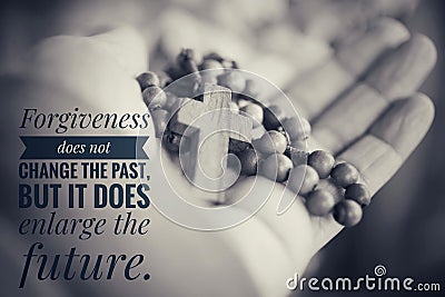 Inspirational quote - Forgiveness does not change the past but it does enlarge the future. With wooden Rosary and Jesus Christ Stock Photo