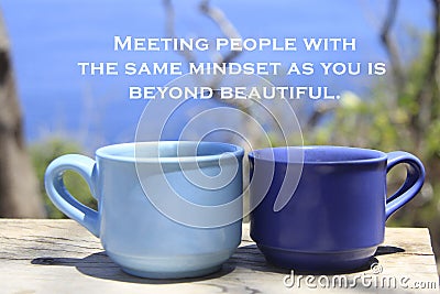 Inspirational quote - Meeting people with the same mindset as you beyond beautiful. With cups of coffee on blue outdoor backgroud. Stock Photo