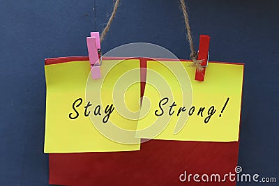 Inspirational quote - Stay strong. With origami paper notes hanging on wall. Encouragement concept with colorful creative papers. Stock Photo