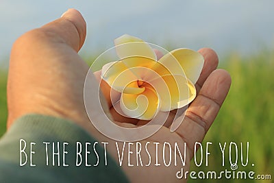 Inspirational single word - Be the best version of you. With woman holding a yellow Bali frangipani flower in hand. Stock Photo